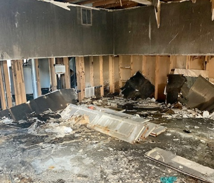 This a picture of a living room after a fire with smoke and soot covering everything. 