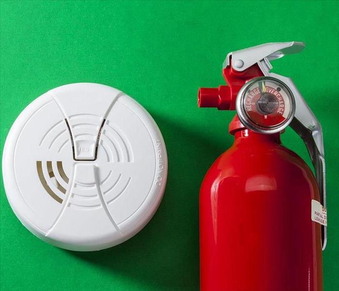 This picture shows a fire extinguisher and a smoke detector. 
