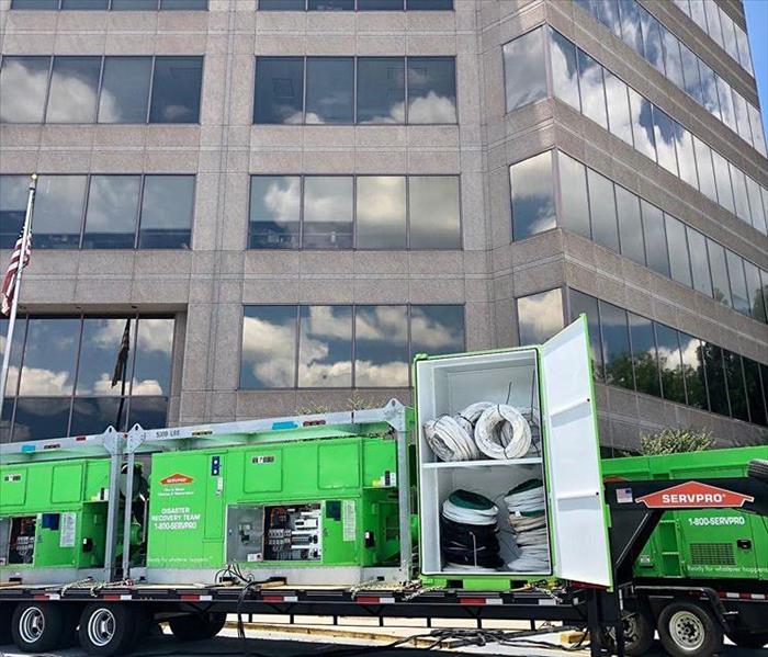 This picture shows a large SERVPRO vehicle fully stocked with equipment in front of a large commercial building. 